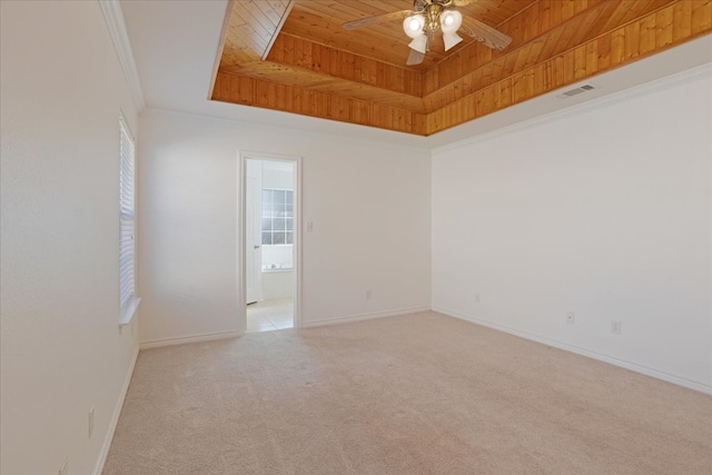 carpeted empty room with ceiling fan, a raised ceiling, wooden ceiling, and crown molding