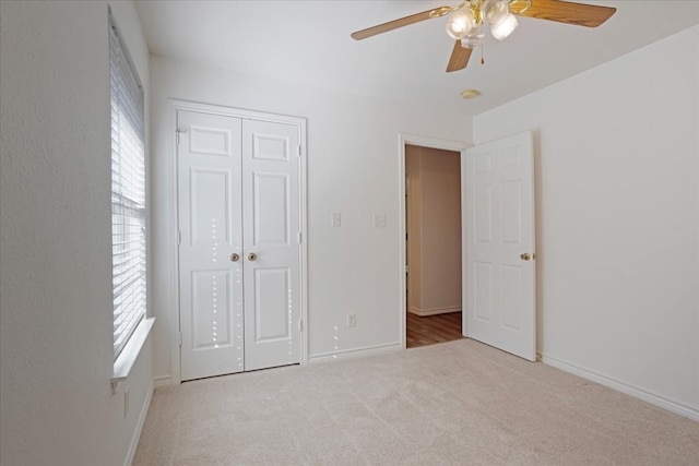 unfurnished bedroom with light carpet, multiple windows, a closet, and ceiling fan