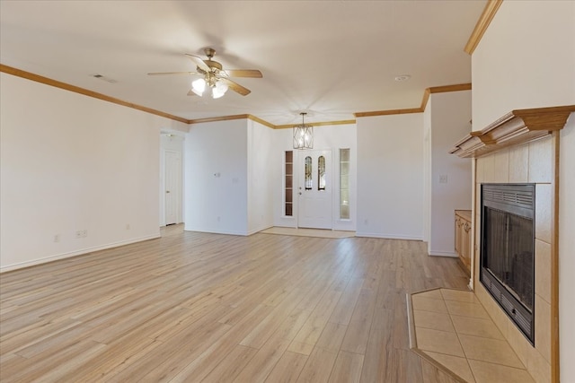 unfurnished living room with ceiling fan with notable chandelier, light hardwood / wood-style floors, ornamental molding, and a tiled fireplace