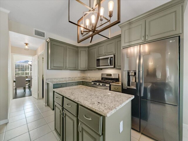 kitchen with appliances with stainless steel finishes, light tile patterned floors, a notable chandelier, a kitchen island, and hanging light fixtures