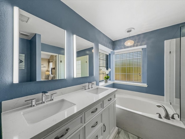 bathroom with a washtub and vanity