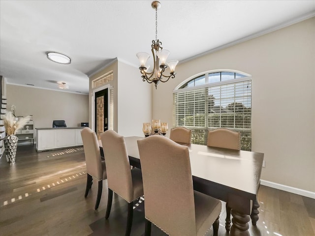 dining space featuring dark hardwood / wood-style flooring, a chandelier, and ornamental molding