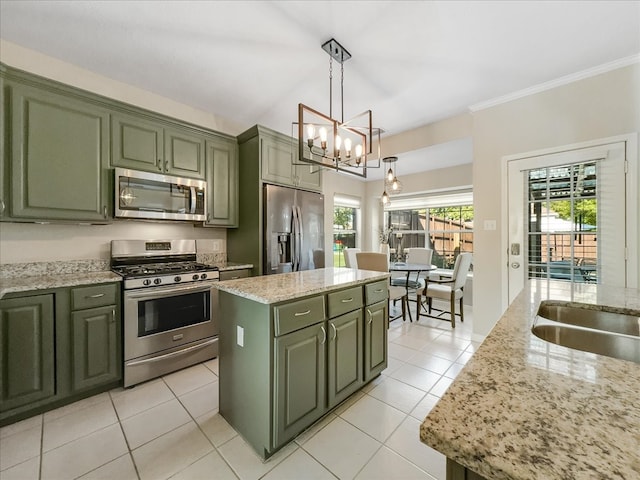 kitchen with a center island, green cabinets, light stone countertops, decorative light fixtures, and stainless steel appliances