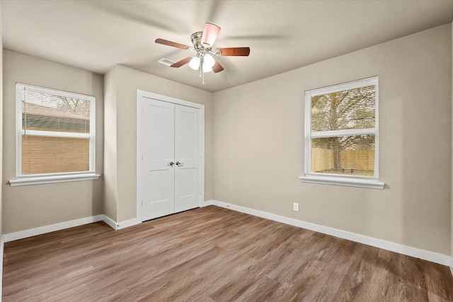 unfurnished bedroom with ceiling fan, a closet, and light hardwood / wood-style floors