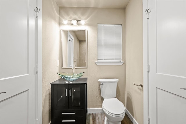 bathroom with vanity, wood-type flooring, and toilet