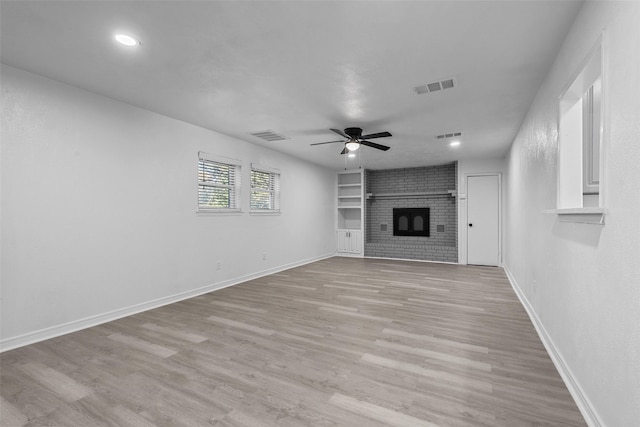 unfurnished living room with ceiling fan, light wood-type flooring, and a fireplace