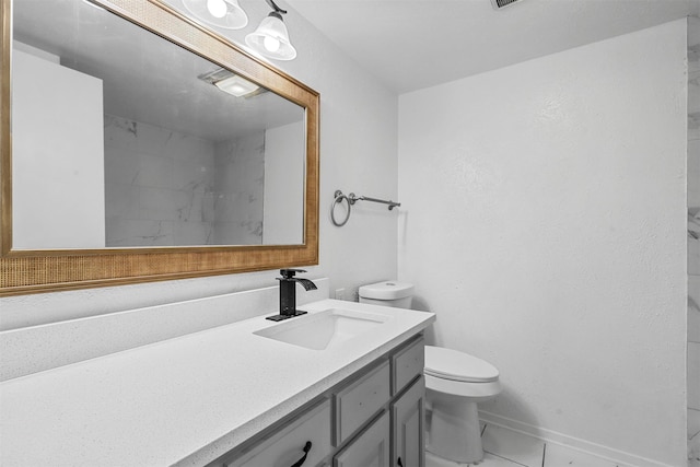 bathroom with tile patterned flooring, vanity, and toilet