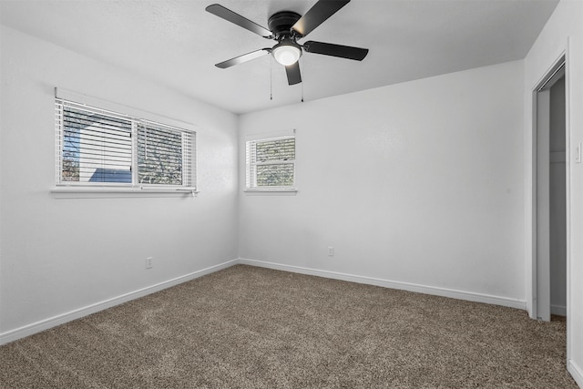 carpeted spare room featuring ceiling fan