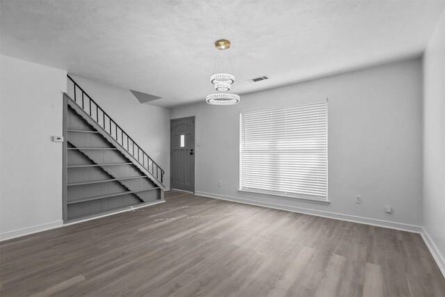 entrance foyer featuring a notable chandelier, dark hardwood / wood-style flooring, and a textured ceiling