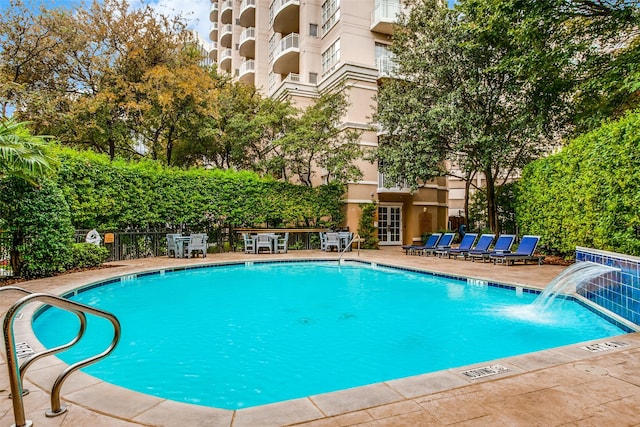 view of swimming pool featuring pool water feature and a patio