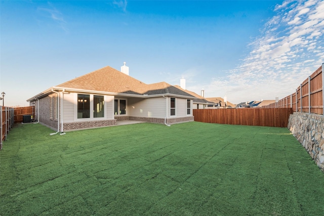 back of house featuring cooling unit and a lawn