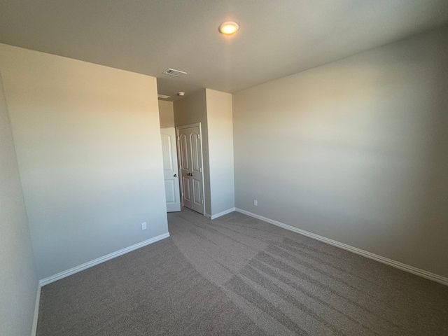 spare room with dark carpet