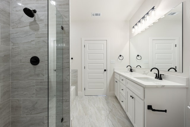 bathroom with a tile shower and vanity