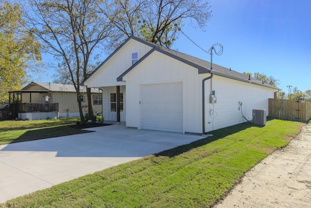 view of front facade with a front lawn, central AC unit, and a garage