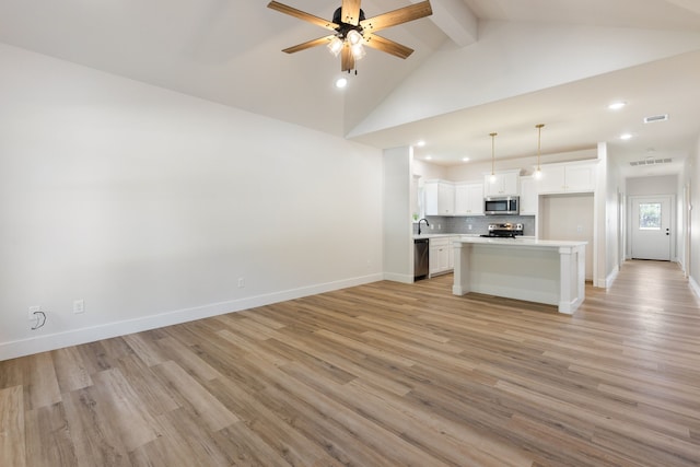 unfurnished living room featuring vaulted ceiling with beams, ceiling fan, and light hardwood / wood-style flooring