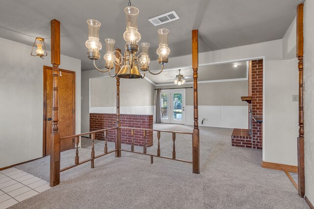 carpeted dining space with french doors and ceiling fan with notable chandelier