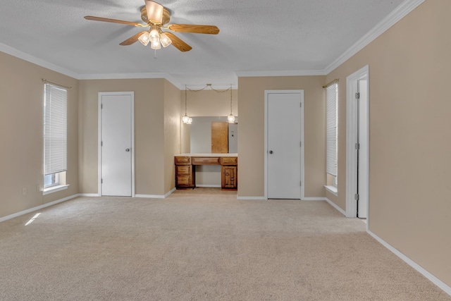 unfurnished bedroom featuring light carpet, ensuite bathroom, ornamental molding, two closets, and ceiling fan