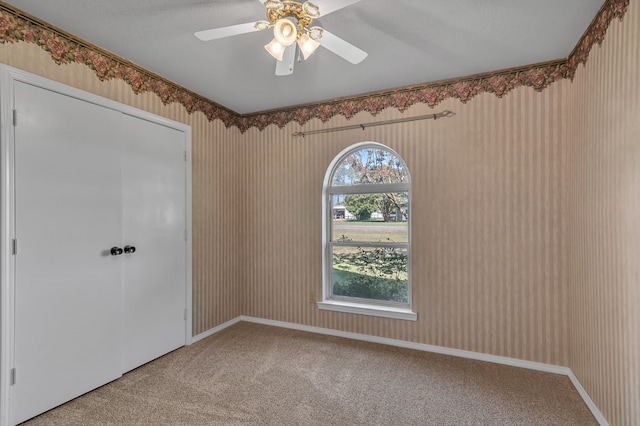 unfurnished room with carpet flooring and ceiling fan