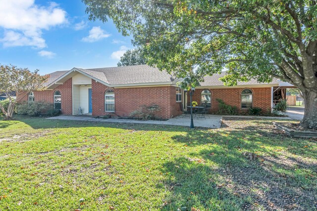 ranch-style house with a front lawn and a patio