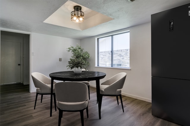 dining room featuring a textured ceiling, dark hardwood / wood-style floors, and a notable chandelier