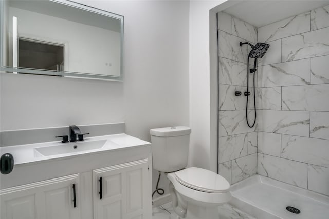 bathroom featuring vanity, toilet, and tiled shower