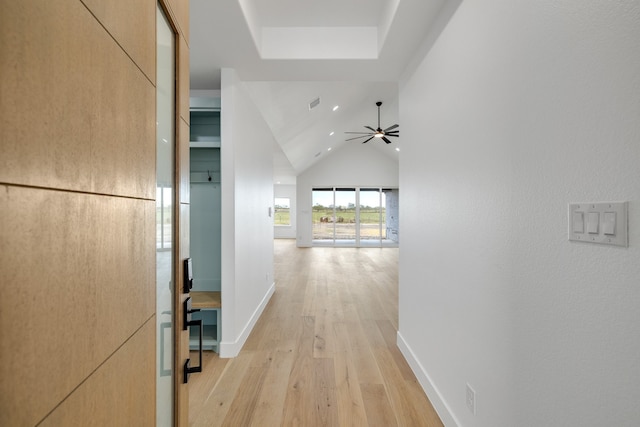 hallway featuring vaulted ceiling and light hardwood / wood-style flooring