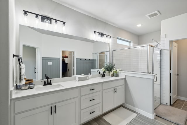 bathroom featuring hardwood / wood-style floors, vanity, and a shower with shower door