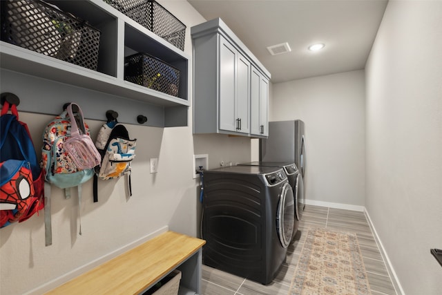 clothes washing area with washer and dryer and light hardwood / wood-style flooring