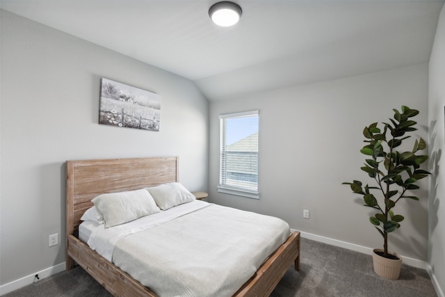 bedroom featuring dark carpet and vaulted ceiling