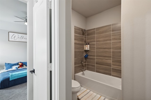 bathroom with ceiling fan, toilet, and tiled shower / bath