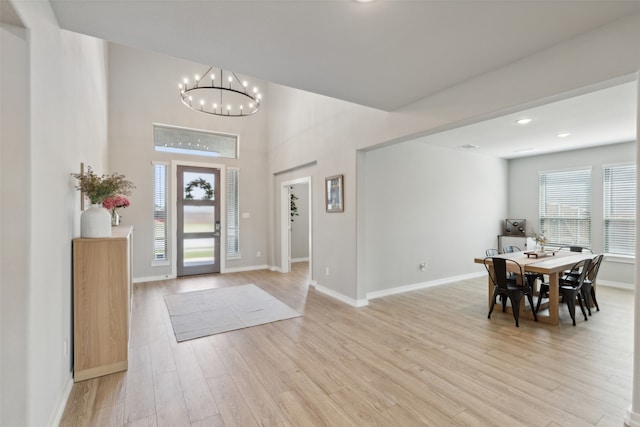 foyer featuring light wood-type flooring and a chandelier