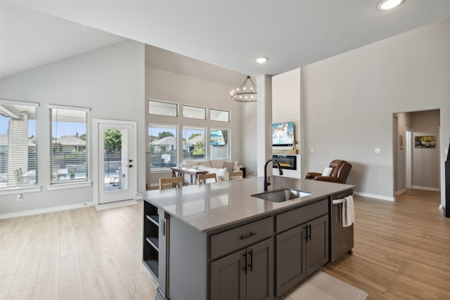 kitchen featuring light stone counters, sink, dishwasher, and light hardwood / wood-style floors