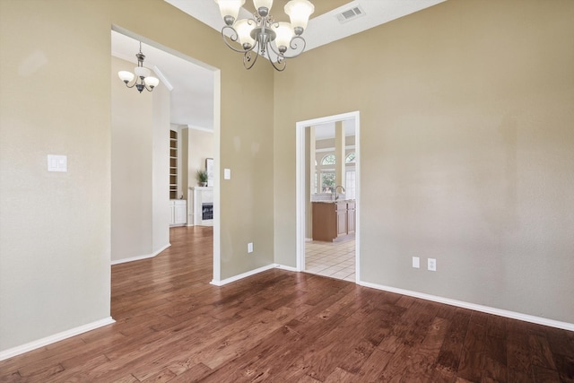 empty room featuring hardwood / wood-style floors and an inviting chandelier