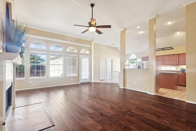 unfurnished living room featuring a textured ceiling, light hardwood / wood-style flooring, ceiling fan, and a healthy amount of sunlight