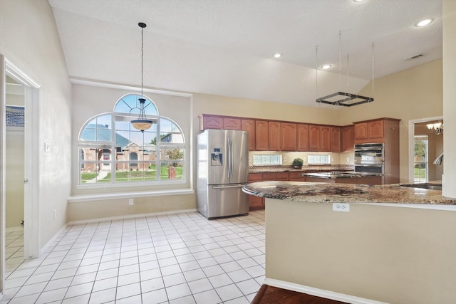 kitchen with hanging light fixtures, sink, vaulted ceiling, appliances with stainless steel finishes, and kitchen peninsula