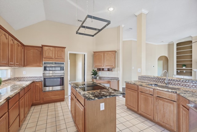 kitchen with sink, a center island, stainless steel appliances, stone countertops, and light tile patterned floors