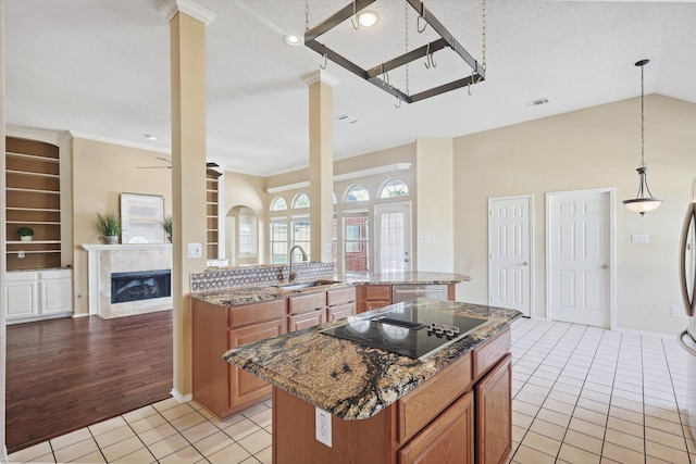 kitchen with a textured ceiling, light hardwood / wood-style floors, a kitchen island, and sink