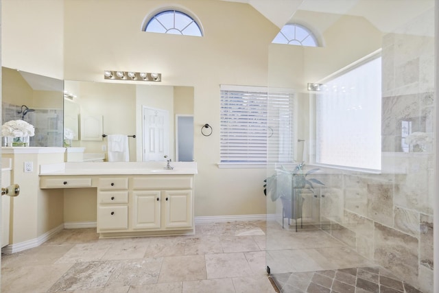 bathroom with vanity, high vaulted ceiling, and tiled shower