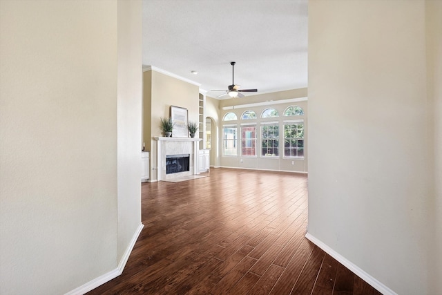 unfurnished living room with ceiling fan, crown molding, a high end fireplace, and wood-type flooring