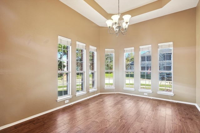 unfurnished room featuring a chandelier and wood-type flooring