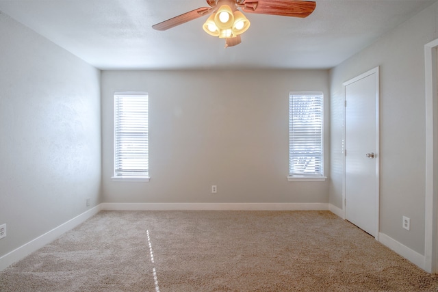 carpeted empty room featuring plenty of natural light and ceiling fan