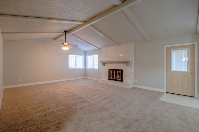 unfurnished living room with light carpet, ceiling fan, vaulted ceiling with beams, a textured ceiling, and a large fireplace