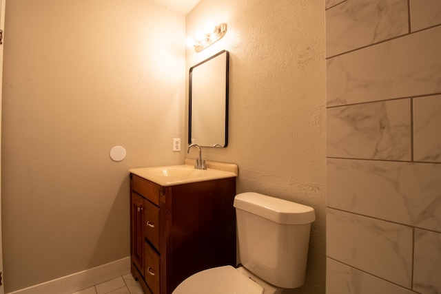 bathroom with tile patterned flooring, vanity, and toilet