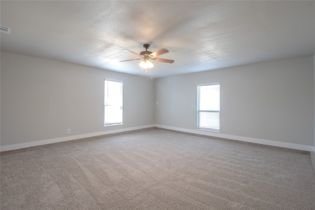 carpeted spare room featuring ceiling fan and a textured ceiling