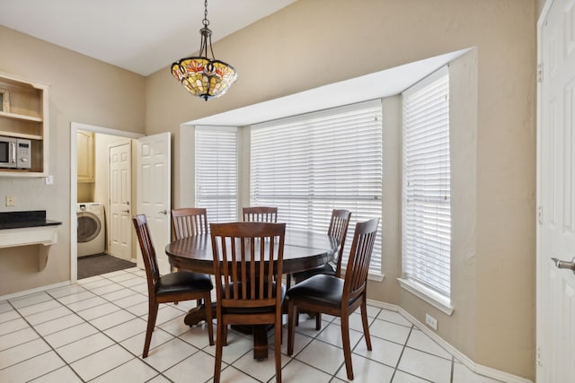 tiled dining room with washer / dryer