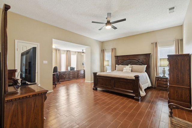 bedroom featuring ceiling fan, dark hardwood / wood-style flooring, and a textured ceiling