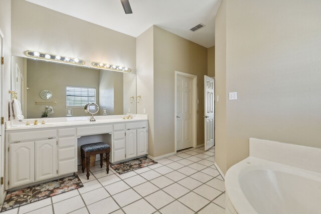 bathroom featuring a bathing tub, tile patterned flooring, and vanity