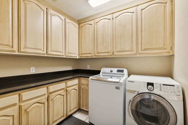 laundry area with cabinets, light tile patterned floors, and washing machine and dryer