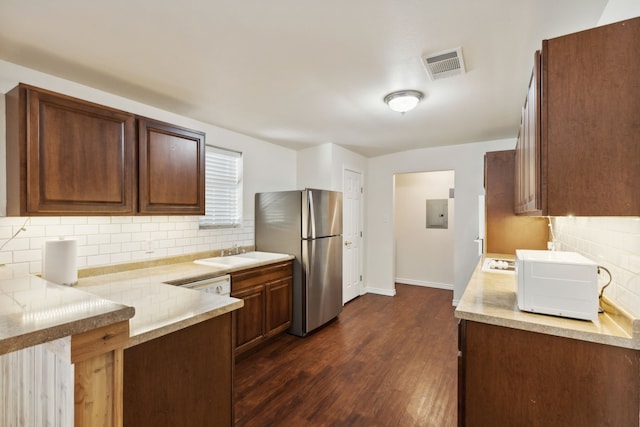 kitchen featuring decorative backsplash, stainless steel fridge, sink, and dark wood-type flooring