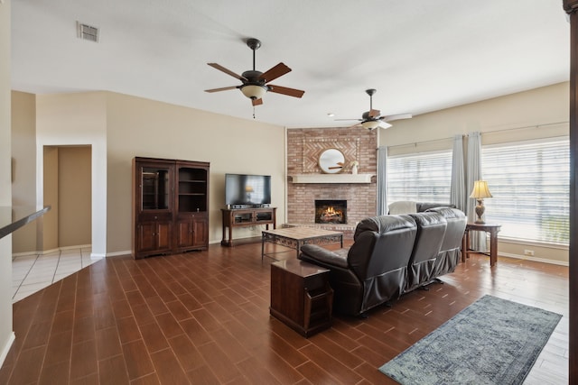 living room featuring a fireplace, ceiling fan, and dark wood-type flooring